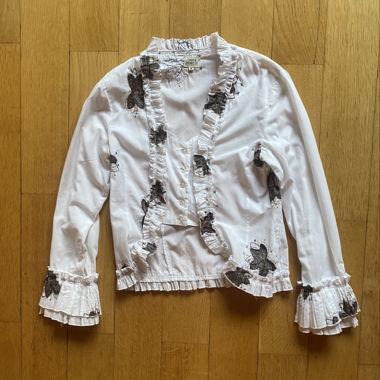 Camicia bianca con ricami floreali e volant