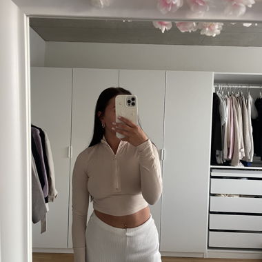 Top beige a maniche lunghe con zip