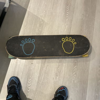 Skateboard mit bunten Fußabdrücken