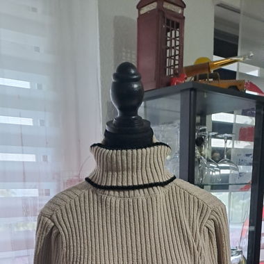 Pull beige avec ceinture.