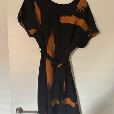 Schwarzes Kleid mit orangenem Print und Gürtel