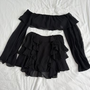 Black top with ruffles and matching skirt