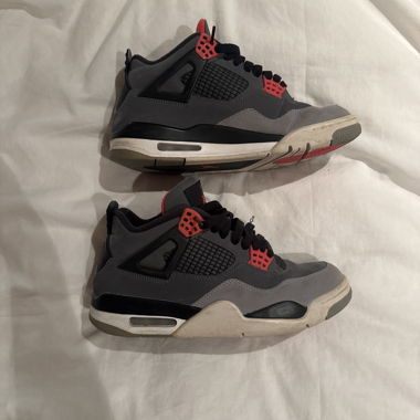 Jordan 4 grigie e nere con dettagli rossi