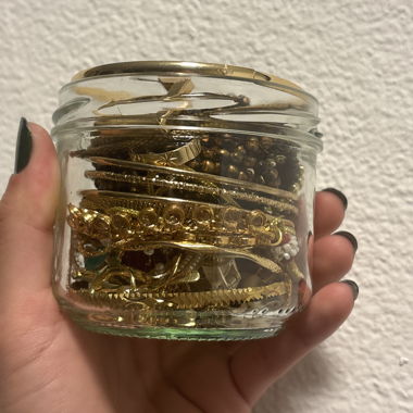 Jewelry jar with gold-colored jewelry