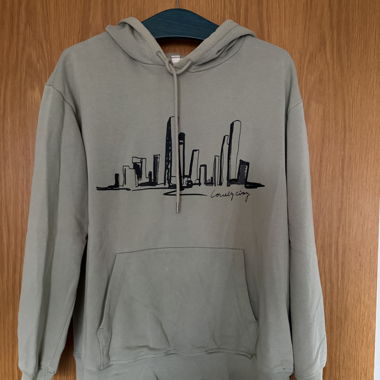 Sweat à capuche vert avec silhouette de la ville