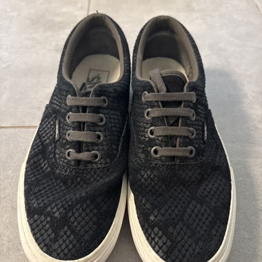 Black Vans sneakers with snake pattern