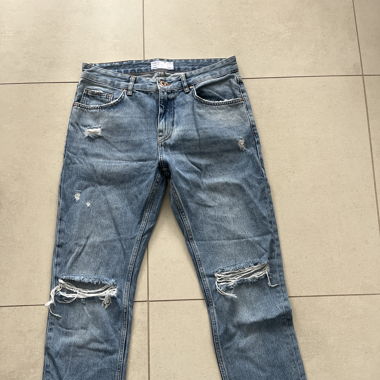 Jeans bleu avec trou aux genoux et fente 