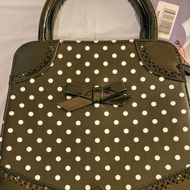 Schwarz gepunktete Handtasche