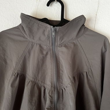 Graue Windjacke mit Tunnelzug