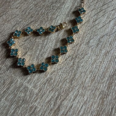 Bracelet fleuri doré à pierres bleues