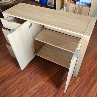 Sideboard aus hellem Holz mit Schubladen und Türen