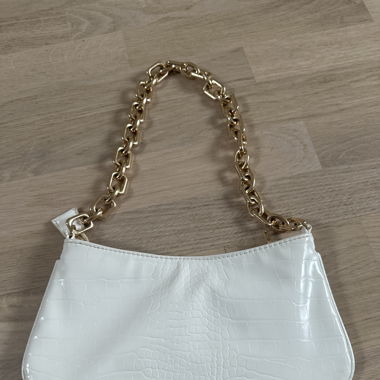 Weisse Tasche mit goldenem Riemen