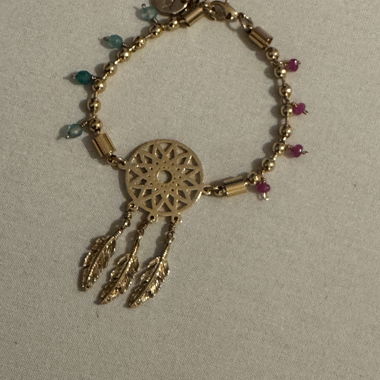 Gold-colored bracelet with feather charm