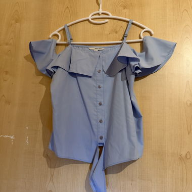 Blusa azzurra con spalle scoperte