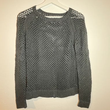 Löchriger, dunkelgrauer, langärmliger Pullover