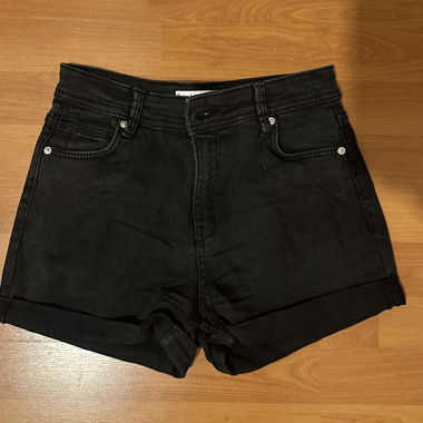 Black denim shorts with rolled hems, four pockets and belt loops.