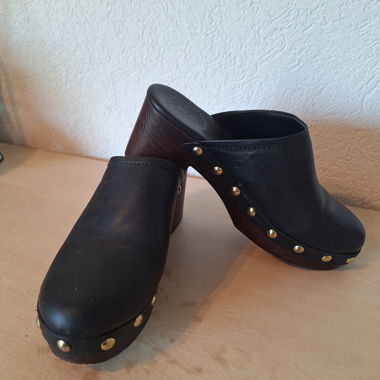 Schwarze Clogs mit Absatz und goldenen Nieten