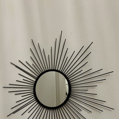 kleiner schwarzer Spiegel in Sonnenform