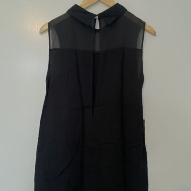 Blusa nera senza maniche con cartellino