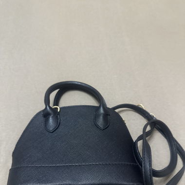 Schwarze Tasche mit Golddetail. 