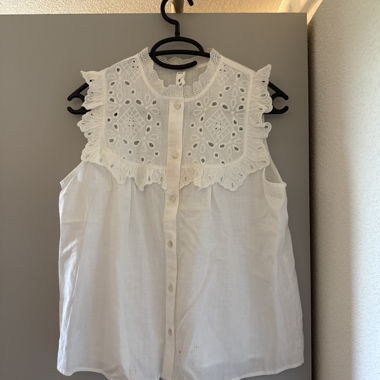 Blusa bianca in pizzo senza maniche