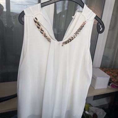 Top elegante color crema con catena dorata