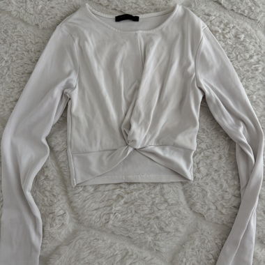Top bianco a coste maniche lunghe con twist frontale