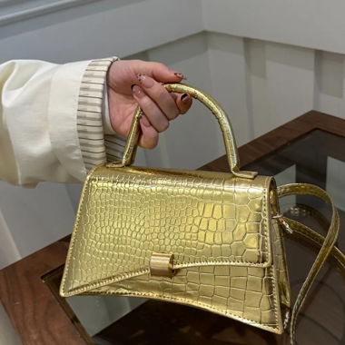 Goldene Handtasche mit Krokodil-Prägung