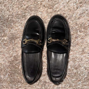 Black loafers with gold detail