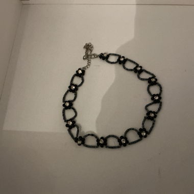 Collana nera con dettagli floreali