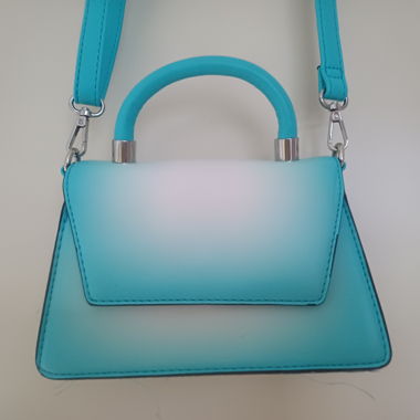 Tuerkisfarbene und weisse Schultertasche