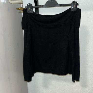 Maglione nero scollato sulla spalla