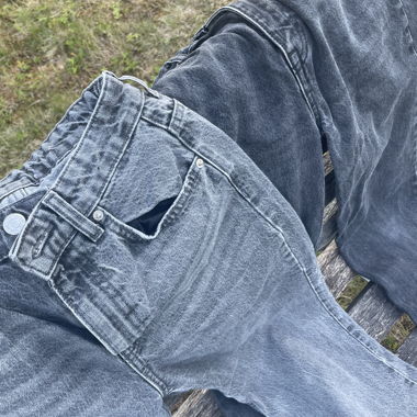 Jeans grigi con orlo con frange
