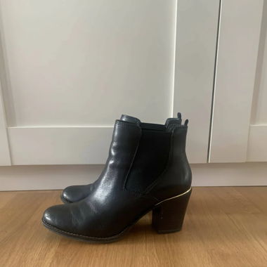 Schwarze elegante Absatzschuhe mit goldenem Detail