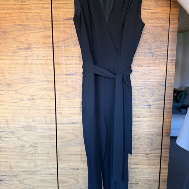 Black sleeveless jumpsuit with tie belt