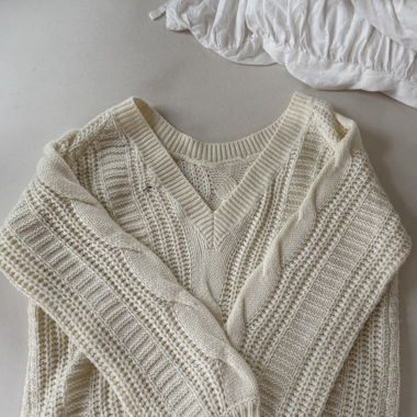 Cream-coloured knitted sweater with cable pattern