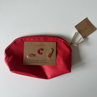 Pochette cosmetica rossa Clarins con pins