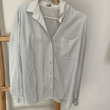 Blusa azzurra chiara con tasca sul petto