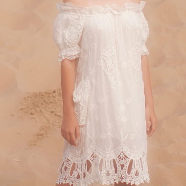 Robe blanche en coton et dentelle décolletée sur l’épaule