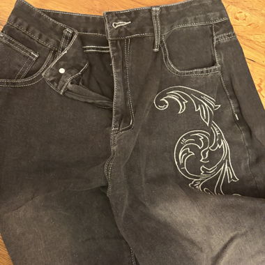 Jeans neri con ricamo a ali
