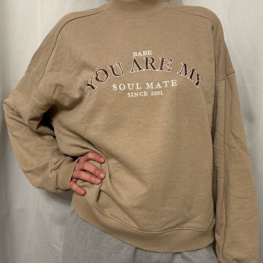maglione beige con testo marrone