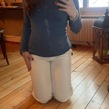 Maglietta blu a maniche lunghe con jeans bianchi e camicia