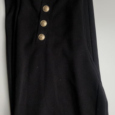 Pantaloni da donna neri elastici con bottoni dorati