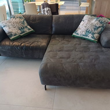 Divano ad angolo grigio in pelle con chaise longue a destra e piedi neri