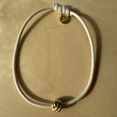 Beige bracelet with golden bead