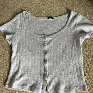 Haut gris à manches courtes avec patte de boutonnage
