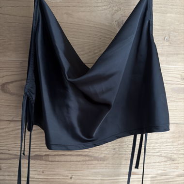 Schwarzes Satin-Top mit dünnen Trägern und offenem Rücken
