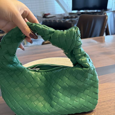 grüne geflochtene Handtasche