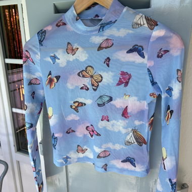 Top trasparente con stampa farfalle, ombelico scoperto