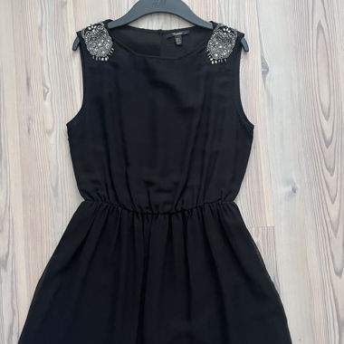 Schwarzes Damenkleid mit Schmuckdetails